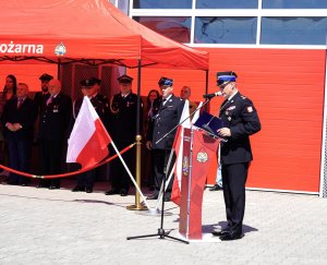 Mężczyzna w mundurze strażaka przy mikrofonie