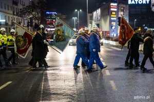 Ludzie maszerują ulicą miasta.