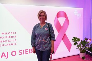Kobieta w tle tablicy informacyjnej