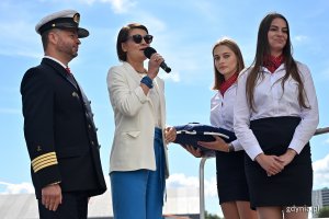 Wiceprezydent Gdyni Katarzyna Gruszecka-Spychała oraz kpt. ż. w. Wojciech Jurgas podczas ceremonii nadania nazwy nowej jednostce. Obok nich stoją dwie hostessy // fot. Michał Puszczewicz