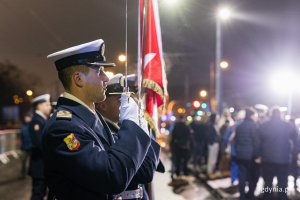 Oficer Marynarki Wojennej stoi z szablą.