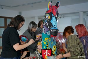 Uczniowie Państwowego Liceum Sztuk Plastycznych w Gdyni malujący rzeźbę konia, kt&oacute;rą miasto przekaże na licytację WOŚP 