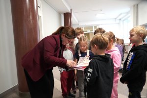 Kobieta w bordowej marynarce z dziećmi