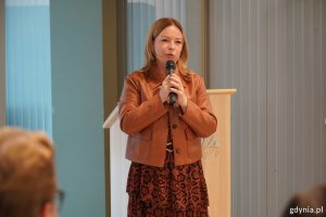 Oktawia Gorzeńska, wiceprezydentka Gdyni z mikrofonem podczas spotkania w InfoBoksie