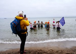 Kobieta w ż&oacute;łtej kurtce fotografuje morsy