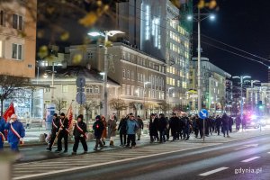 Ludzie w odświętnych strojach idący ulicą