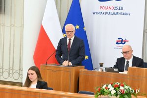 Senator Sławomir Rybicki stojący przy mównicy na sali obrad Senatu