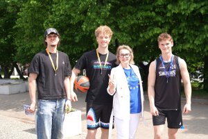 Kobieta w białej marynarce i trzej młodzi mężczyźni