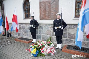 Marynarze i kwiaty pod tablicą przy Bazylice Morskiej