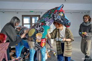 Uczniowie Państwowego Liceum Sztuk Plastycznych w Gdyni malujący rzeźbę konia, kt&oacute;rą miasto przekaże na licytację WOŚP 