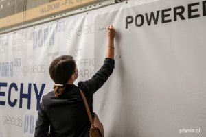Wiceprezydent Katarzyna Gruszecka-Spychała składa podpis na pamiątkowym banerze. // fot. Karol Stańczak