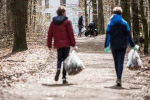 Sprzątanie lasu na Karwinach: para niesie wypełnione śmieciami worki, fot. Karol Stańczak
