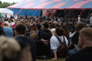 Uczestnicy Open'era siedzący na trawie na terenie festiwalu // fot. Magda Zaklika