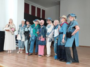 Bożena Zglińska &ndash; dyrektorka Centrum Aktywności Seniora w Gdyni z uczestniczkami grupy &bdquo;Warsztaty modą kreowane&rdquo; podczas pokazu mody zorganizowanego z okazji zakończenia roku akademickiego 2025/2026 Gdyńskiego Uniwersytetu Trzeciego Wieku