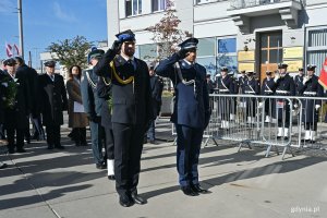 Przedstawiciele Komendy Miejskiej Policji oraz Państwowej Straży Pożarnej składający kwiaty pod pomnikiem podczas uroczystości z okazji 87. rocznicy pierwszych wysiedleń Gdynian