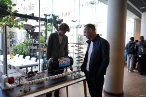 Młody mężczyzna na stoisku, starszy się przygląda wystawie