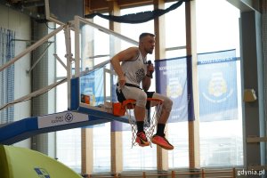 Prowadzący mikołajki Kacper „Kacpa” Lachowicz siedzi na koszu