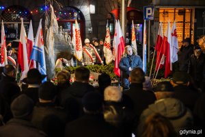Mężczyzna przemawiający przed pomnikiem