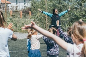 Zumba na boisku szkolnym, na pierwszym planie prowadząca