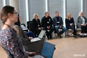 Kobiety i mężczyźni siedzący na krzesłach w sali konferencyjnej