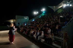 Widzowie i dyrektorka Teatru Miejskiego w Gdyni na Scenie Letniej po zmroku