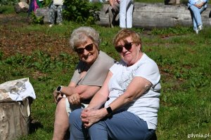 Dwie seniorki siedzące na pniu drzewa 
