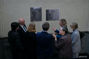 Goście zaproszeni na inaugurację wystawy w sądzie przyglądający się ekspozycji 