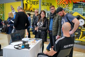 Uczestnicy akcji z okazji Dnia Mężczyzny przy stoisku fizjoterapeuty 