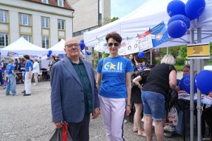 Mężczyzna w garniturze, kobieta w niebieskiej koszulce 