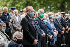 Uczestnicy gdyńskich obchodów Dnia Sybiraka stoją w rzędzie. Na pierwszym planie, w niebieskiej maseczce, wiceprezydent Gdyni Michał Guć. Obok, w zielonej maseczce, wicewojewoda pomorski Mariusz Łuczyk // fot. Karol Stańczak