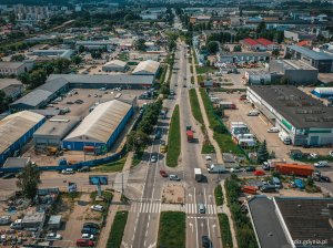 widok z góry na ulicę, widoczny ruch uliczny, budynki w tle