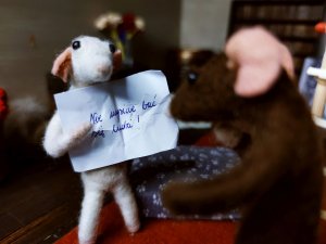 Biała myszka Florentyna trzyma kartkę z napisem "Nie musicie bać się ludzi". Przed nią stoi brązowa myszka Ernest, który czyta kartkę // fot. Aneta Rychert, Mysie opowieści