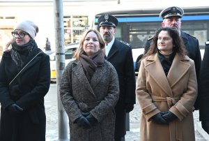 Trzy kobiety w płaszczach, w tle marynarze