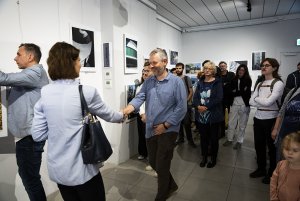 Kobieta gratuluje mężczyźnie na gali konkursu fotografii.