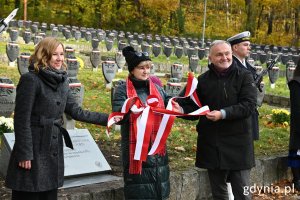 Na zdj. stoją na cmentarzu (od lewej):  Katarzyna Lisiecka, naczelnik Oddziałowego Biuro Upamiętniania Walk i Męczeństwa IPN W Gdańsku, Małgorzata Sokołowska, inicjatorka tablicy i prezydent Gdyni Wojciech Szczurek