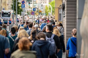 Uczestnicy spaceru Szlakiem Filmowym Gdyni zgromadzeni idący ul. 10 Lutego 
