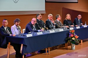 Od lewej: prof. Vincenzo Piuri – były dyrektor IEEE Region 8, dr Tiziana Tombosso – wiceprzewodnicząca ds. projektów technicznych IEEE Region 8, prof. Mike Hinchey – dyrektor IEEE Region 8, prof. dr hab. inż. kpt. ż.w. Adam Weintrit – rektor Uniwersytetu Morskiego w Gdyni, prof. Mariusz Malinowski – prorektor ds. badań Politechniki Warszawskiej, prof. Marek Jasiński – przewodniczący polskiej sekcji IEEE , wiceprezydentka Gdyni Oktawia Gorzeńska oraz Łukasz Dąbrowski – kierownik Referatu Transformacji Energetycznej Urzędu Marszałkowskiego Województwa Pomorskiego siedzą za stołem podczas otwarcia konferencji 