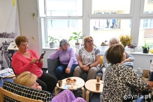 Kilka kobiet siedzi przy stolikach