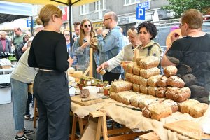 Jedno ze stoisk na festiwalu „Kulinarna Świętojańska”. Na pierwszym planie obsługa oraz chleby i pasty do pieczywa. Przy stoisku - kolejka klientów // fot. Magdalena Czernek