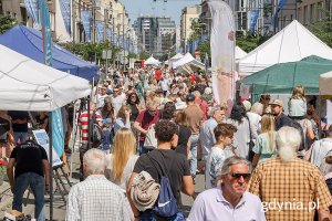 Uczestnicy wydarzenia chodzą między stoiskami na ul. Świętojańskiej 