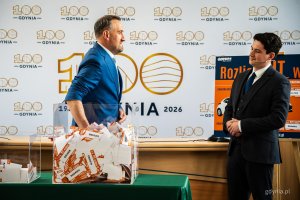Wiceprezydent Gdyni Tomasz Augustyniak losujący zwycięski kupon podczas finału loterii &bdquo;Rozlicz PIT w Gdyni&rdquo;. Obok niego Piotr Pisarek &ndash; członek komisji nadzoru loterii z firmy Gratifica