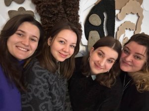 Kobiety na tle białej ściany z czarnymi, beżowymi i brązowymi dekoracjami