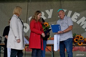 Beata Zastawna &ndash; przewodnicząca Rady Miasta Gdyni i Hanna Niedźwiecka-Pasternak &ndash; zastępca naczelnika Wydziału Ogrodnika Miasta wręczają nagrodę jednemu z uczestnik&oacute;w konkursu &bdquo;Gdynia w kwiatach&rdquo; 