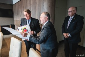 Prezydent Gdyni Wojciech Szczurek i JE Ramiro Fernández - ambasador Królestwa Hiszpanii w Polsce przekazują sobie okolicznościowe upominki. Z tyłu: Maciej Dobrzyniecki, konsul honorowy Hiszpanii w Gdańsku podczas spotkania w Urzędzie Miasta Gdyni // fot. Kamil Złoch
