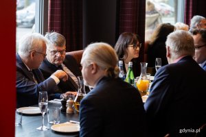 Ludzie rozmawiają przy stole w restauracji.
