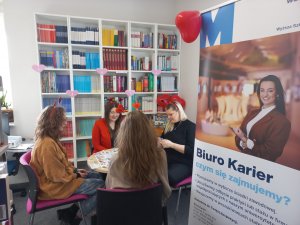 cztery panie grające w grę planszową w bibliotece