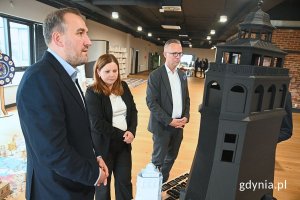 Grupa osób przyglądająca się makiecie budynku