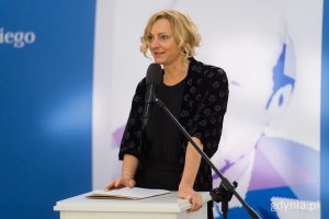 Kobieta z jasnymi włosami w ciemnej sukience
