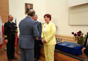 Mężczzna w garniturze gratuluje kobiecie w cystrynowym kostiumie