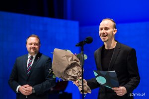 Filip Wójcik, aktor Teatru Gdynia Główna, z nagrodą z okazji Międzynarodowego Dnia Teatru. Na scenie w towarzystwie wiceprezydenta Gdyni Marka Łucyka // fot. Karol Stańczak